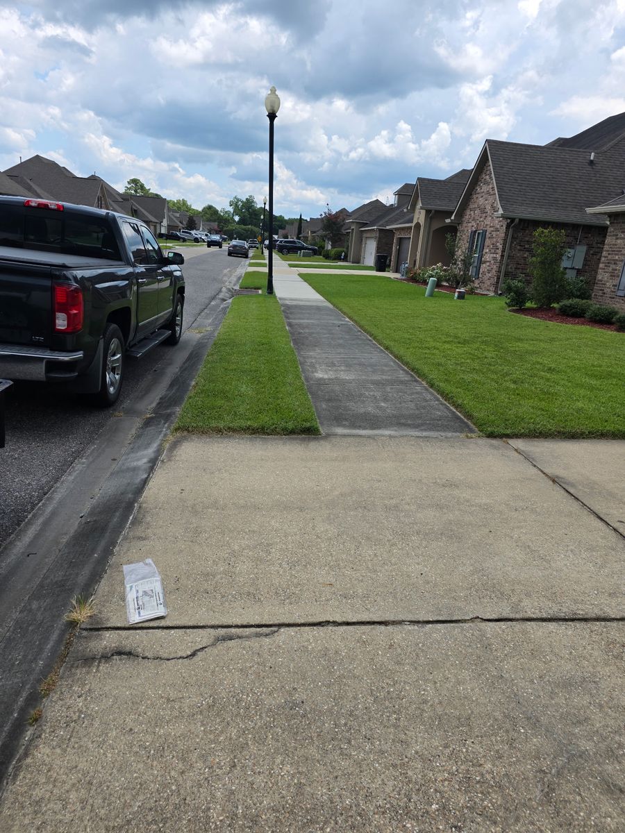 Driveway and sidewalk before cleaning, concrete dulled gray with dirt and staining